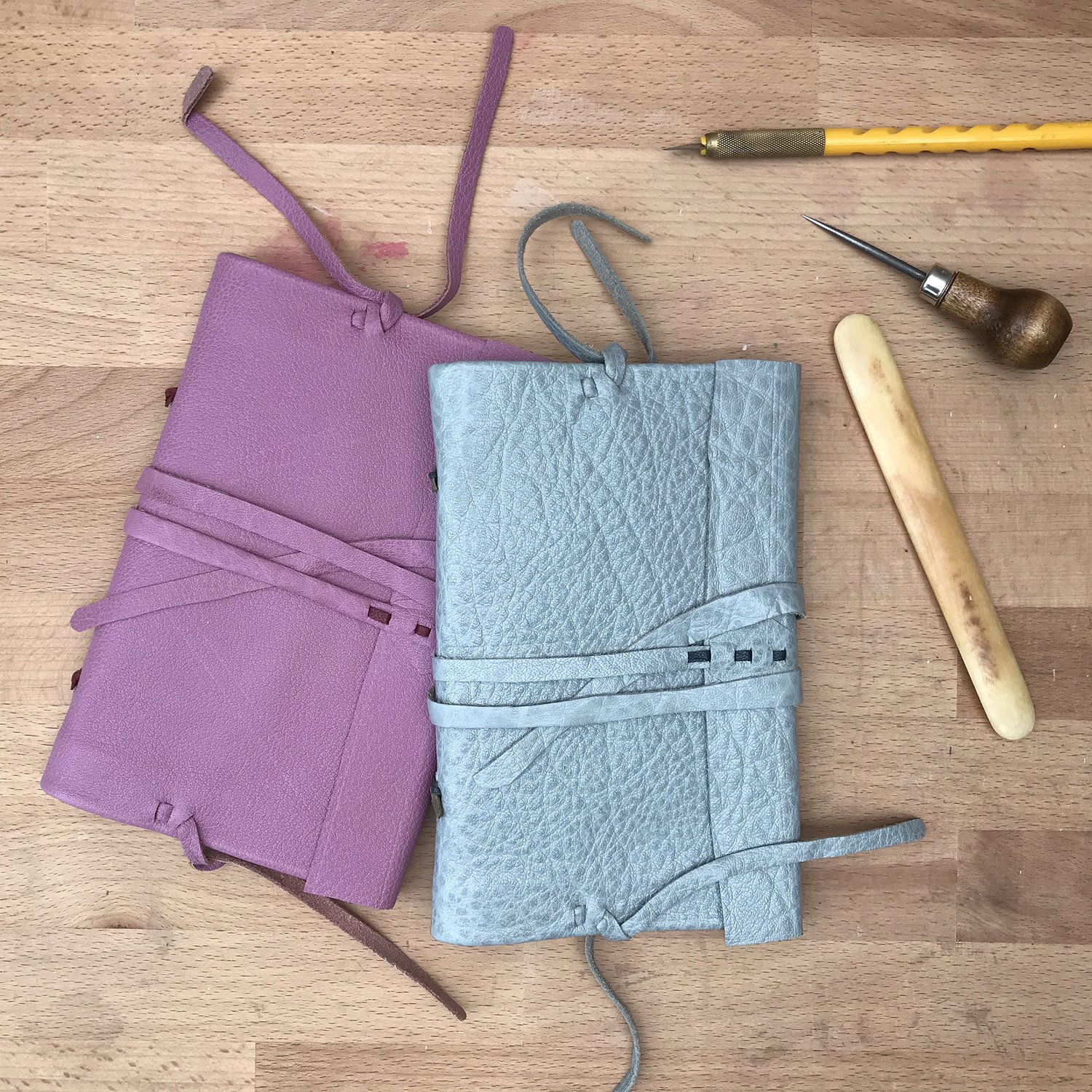 two leather bound books with tools